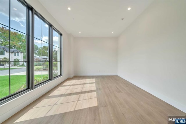 spare room with light wood finished floors, baseboards, and recessed lighting