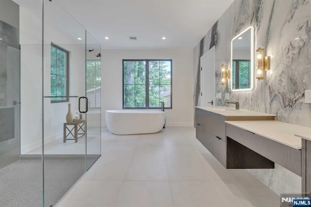 full bath with recessed lighting, a freestanding bath, a stall shower, vanity, and tile patterned floors