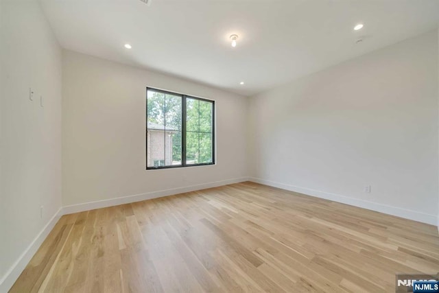 empty room with recessed lighting, light wood-style flooring, and baseboards