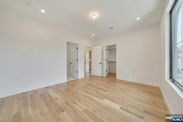 spare room with recessed lighting, visible vents, light wood-style flooring, and baseboards