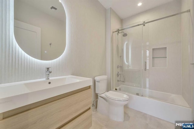 bathroom with visible vents, toilet, enclosed tub / shower combo, vanity, and tile patterned floors