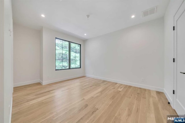 empty room with light wood finished floors, baseboards, visible vents, and recessed lighting