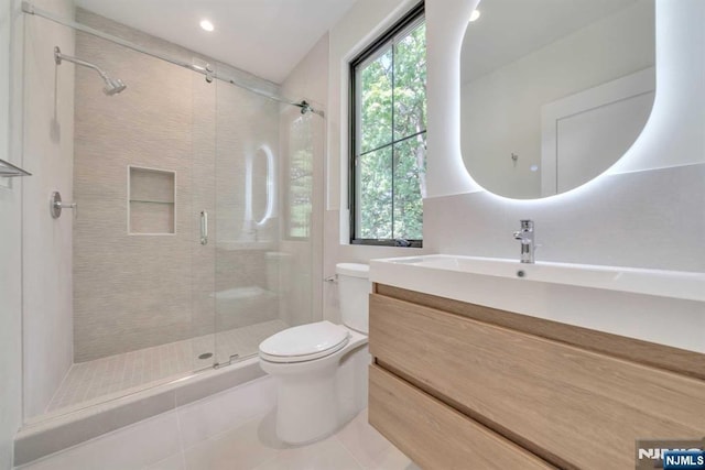 bathroom with toilet, tile patterned flooring, a shower stall, and vanity