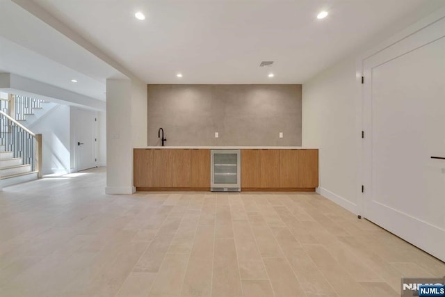 kitchen with recessed lighting, visible vents, modern cabinets, beverage cooler, and baseboards