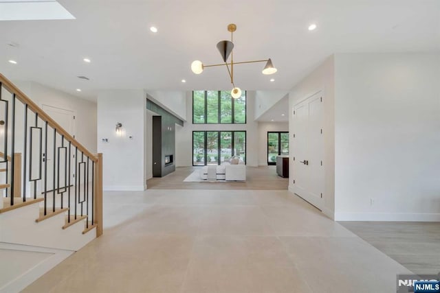 foyer featuring recessed lighting, a skylight, baseboards, stairs, and an inviting chandelier