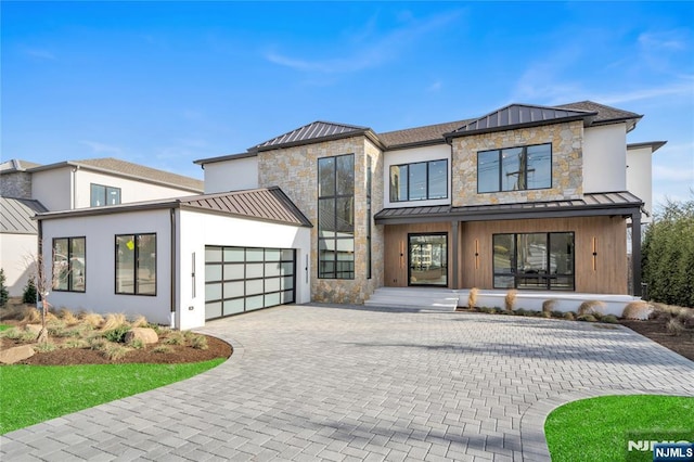 view of front of home featuring stone siding, a standing seam roof, metal roof, and an attached garage