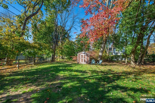 view of yard featuring a storage shed, an outdoor structure, and fence