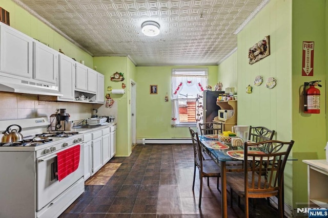 kitchen with an ornate ceiling, under cabinet range hood, gas range gas stove, and baseboard heating