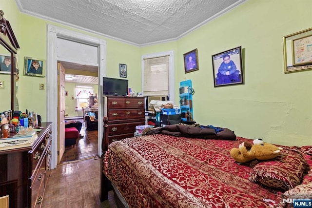 bedroom featuring an ornate ceiling, crown molding, and wood finished floors