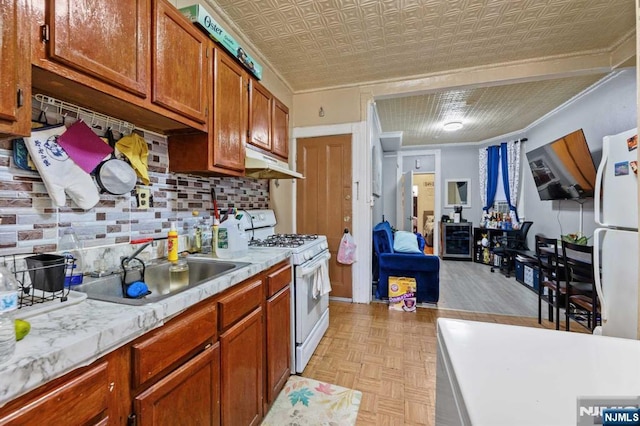 kitchen featuring light countertops, white appliances, a sink, and an ornate ceiling