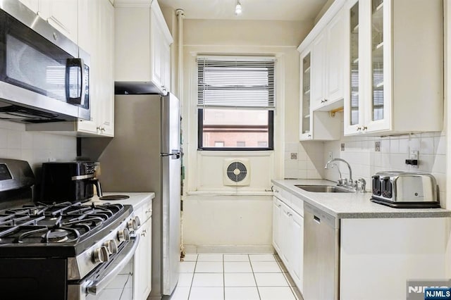 kitchen with white cabinetry, stainless steel appliances, a sink, and light countertops