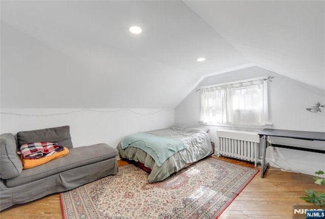 bedroom featuring lofted ceiling, radiator, recessed lighting, and wood finished floors