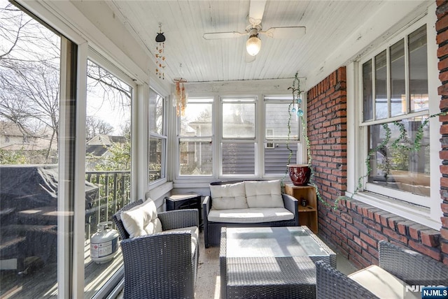 sunroom featuring a ceiling fan, wooden ceiling, and plenty of natural light