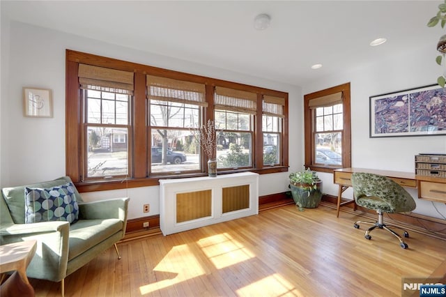 office area with light wood-style flooring, baseboards, radiator heating unit, and recessed lighting