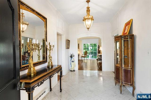 corridor featuring arched walkways and crown molding