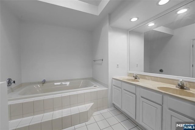 full bathroom with double vanity, tiled bath, a sink, and tile patterned floors