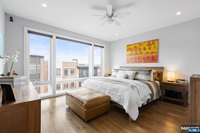 bedroom with a ceiling fan, wood finished floors, access to exterior, a view of city, and recessed lighting