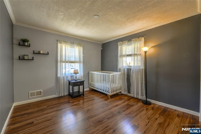 unfurnished bedroom featuring ornamental molding, multiple windows, dark wood finished floors, and visible vents