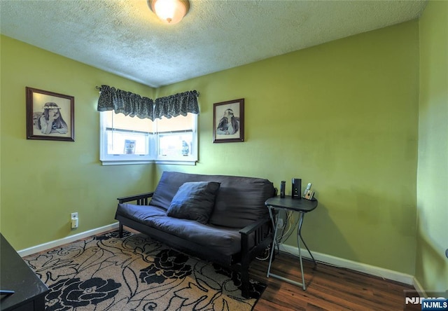 living area with baseboards, dark wood finished floors, and a textured ceiling