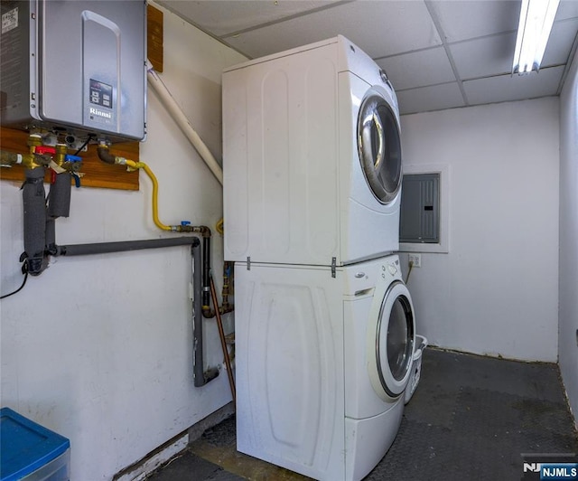 laundry area featuring tankless water heater, stacked washer and clothes dryer, and electric panel