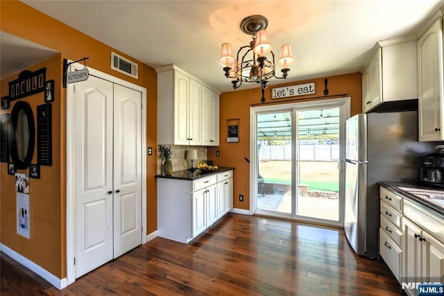 kitchen featuring pendant lighting, tasteful backsplash, visible vents, dark wood-type flooring, and white cabinets