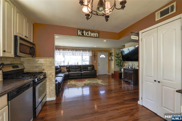 kitchen with dark wood finished floors, a notable chandelier, stainless steel appliances, visible vents, and open floor plan