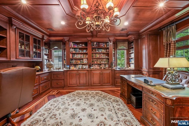 office featuring crown molding, visible vents, built in study area, wood finished floors, and a chandelier