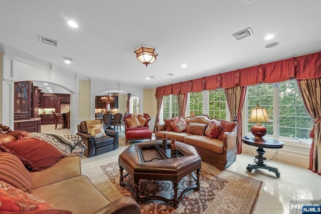 living room with arched walkways, plenty of natural light, visible vents, and recessed lighting