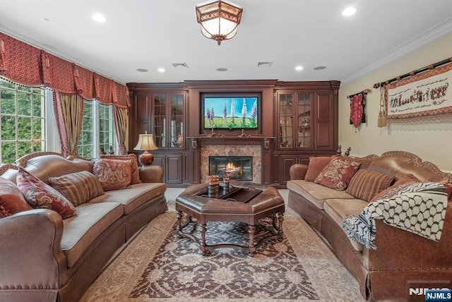 living area with a fireplace, visible vents, crown molding, and recessed lighting