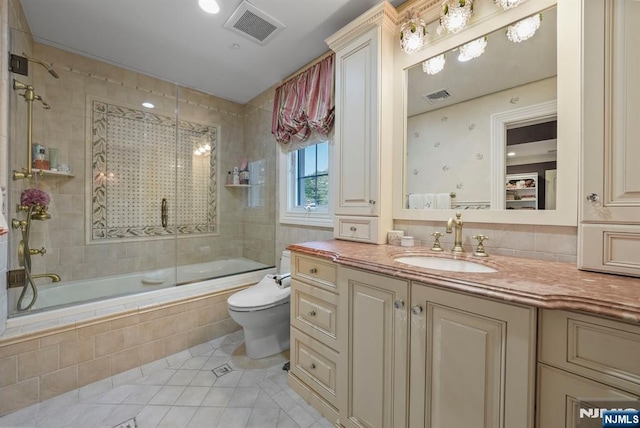 bathroom featuring visible vents, toilet, tiled shower / bath combo, tile patterned flooring, and vanity