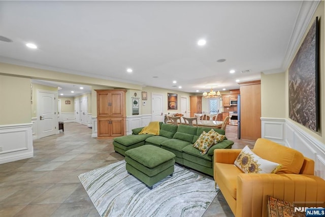 living area featuring ornamental molding, recessed lighting, a chandelier, and a decorative wall