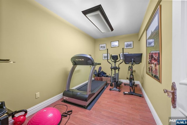 workout area featuring wood finished floors and baseboards