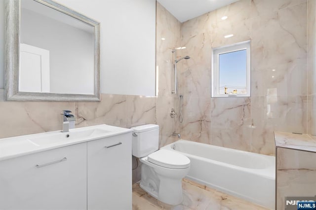 bathroom with shower / washtub combination, marble finish floor, tile walls, toilet, and vanity