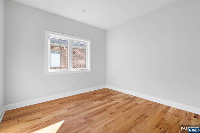 unfurnished room featuring baseboards and wood finished floors