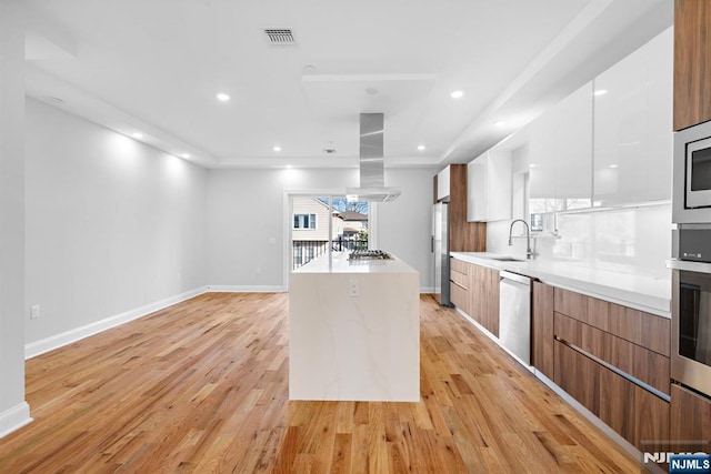 kitchen with stainless steel appliances, brown cabinetry, modern cabinets, and light countertops