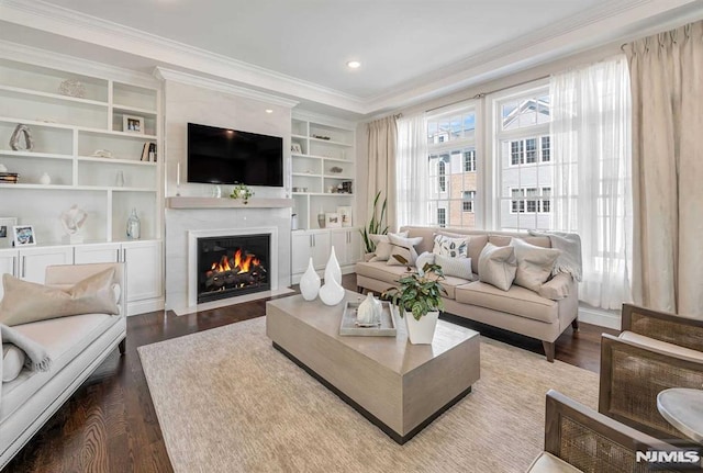 living area featuring built in features, a fireplace, ornamental molding, and wood finished floors