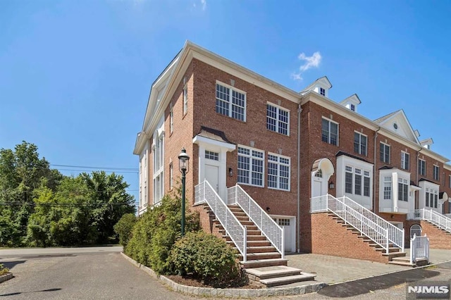 multi unit property featuring brick siding and driveway