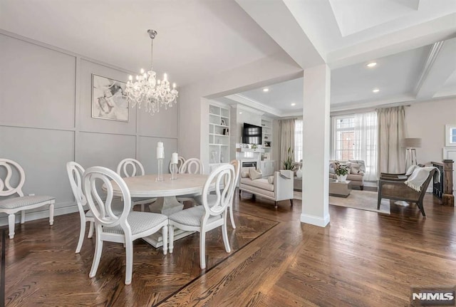 dining area with recessed lighting, a fireplace, built in features, dark wood finished floors, and an inviting chandelier