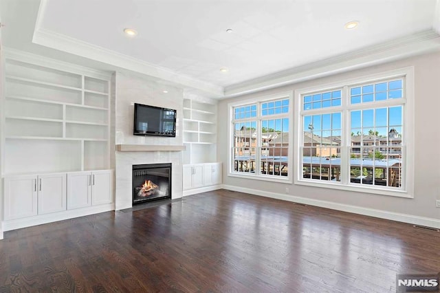 unfurnished living room featuring baseboards, wood finished floors, a wealth of natural light, and a high end fireplace