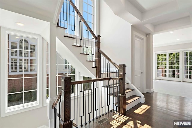 stairs featuring a high ceiling, baseboards, wood finished floors, and recessed lighting