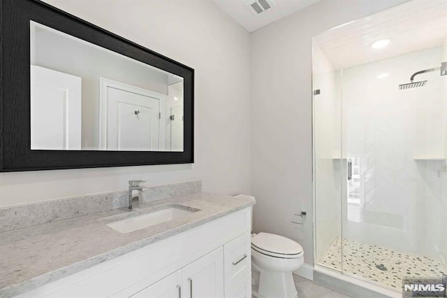 bathroom featuring toilet, a stall shower, visible vents, and vanity