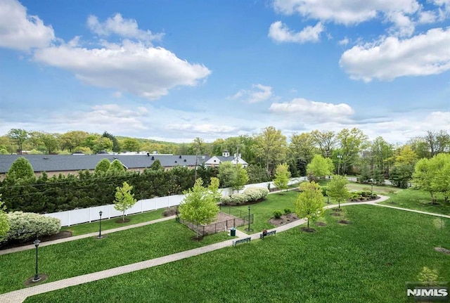 view of community with a yard and fence