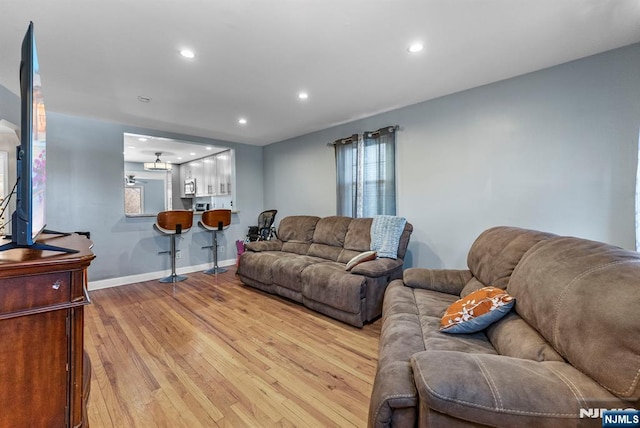 living room featuring recessed lighting, light wood-type flooring, and baseboards