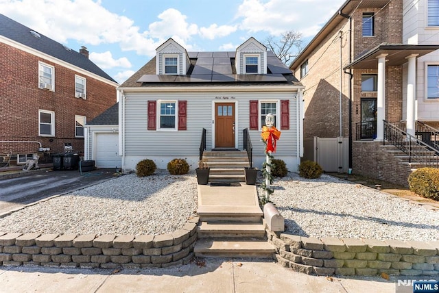 view of front of home featuring entry steps, solar panels, and driveway