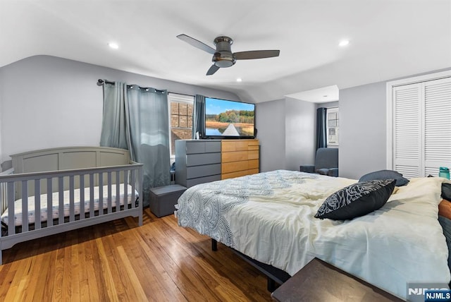 bedroom featuring lofted ceiling, hardwood / wood-style flooring, a closet, and recessed lighting