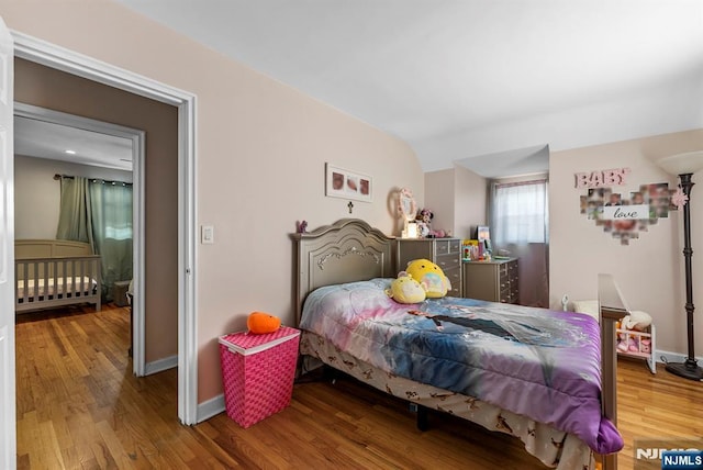 bedroom with baseboards and wood finished floors