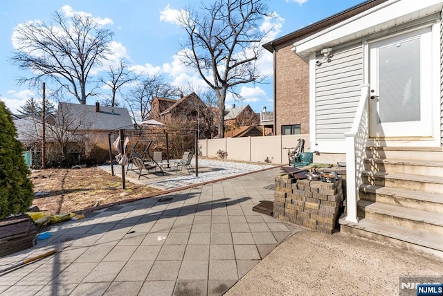 view of patio featuring entry steps and fence