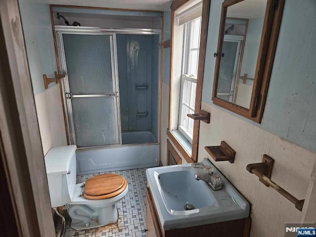 bathroom featuring shower / bath combination with glass door, vanity, toilet, and tile patterned floors