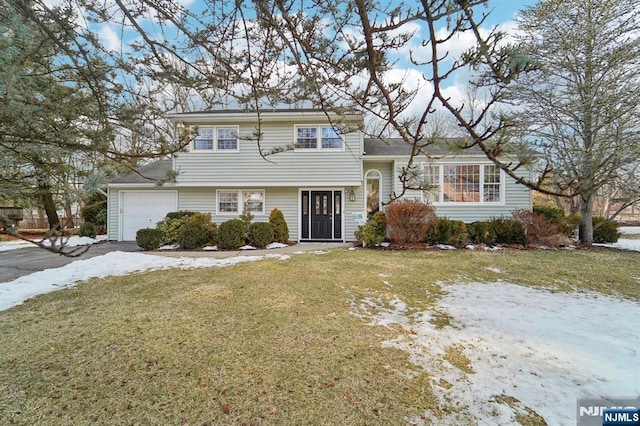 tri-level home featuring a yard and an attached garage