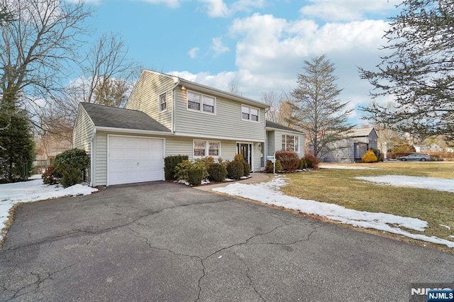 view of front of home with a front lawn, an attached garage, and aphalt driveway